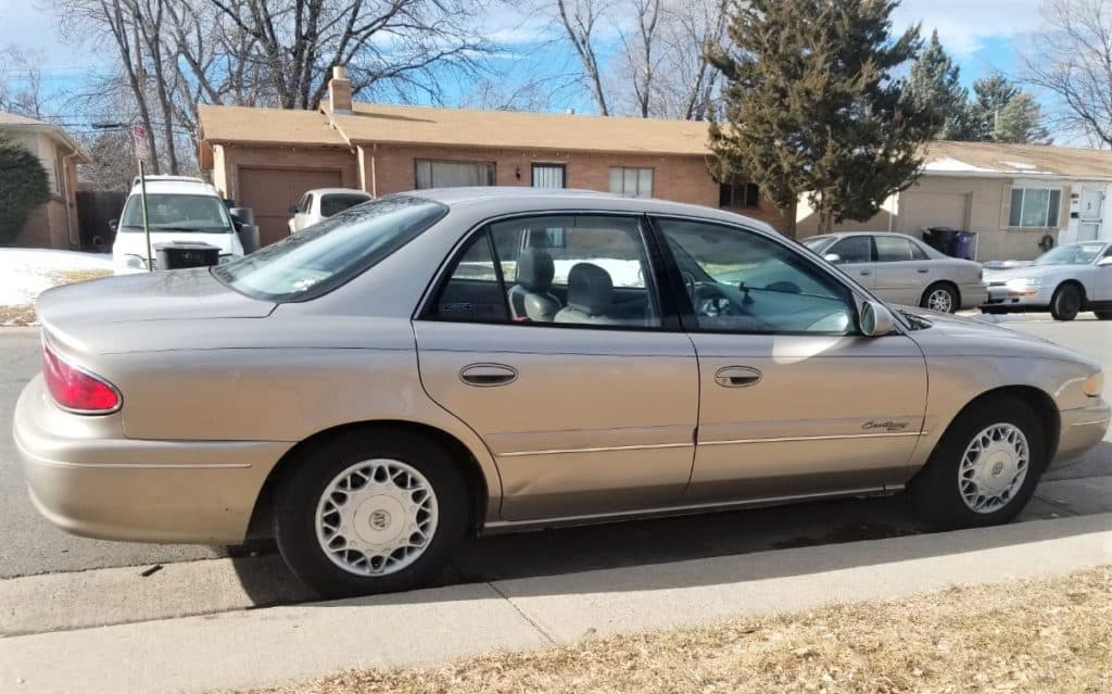 My 1998 Buick Century parked at the curb. This was the car I used to deliver Doordash, Uber Eats, and Grubhub for nearly two and a half years.