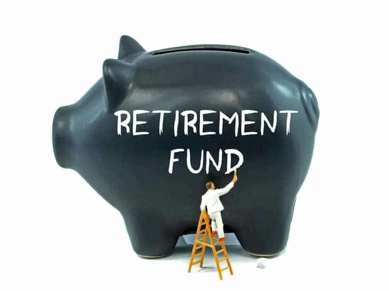 Man painting "Retirement Fund" on large piggy bank.
