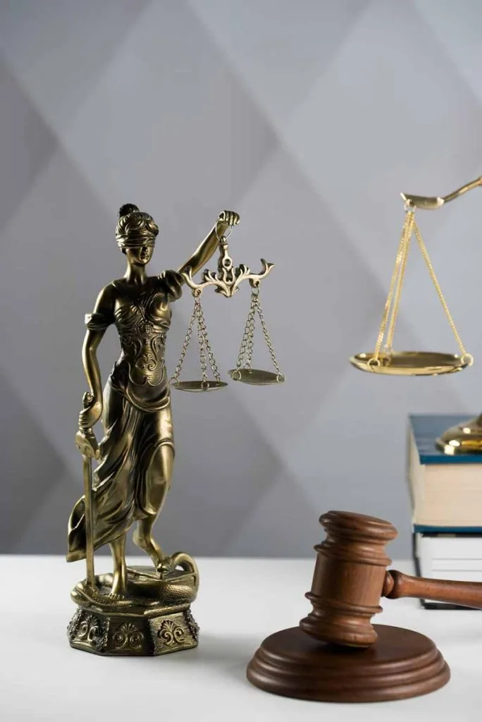 Legal theme related to Doordash arbitration with statue of lady justice, gavel and law books