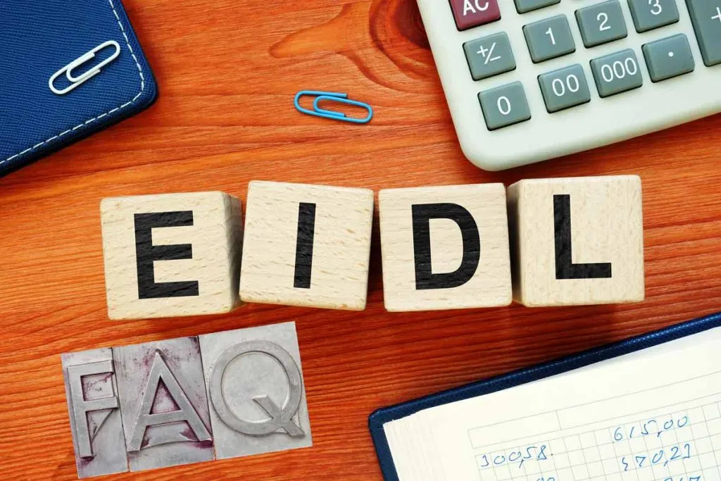 A desktop with items including blocks reading EIDL and FAQ