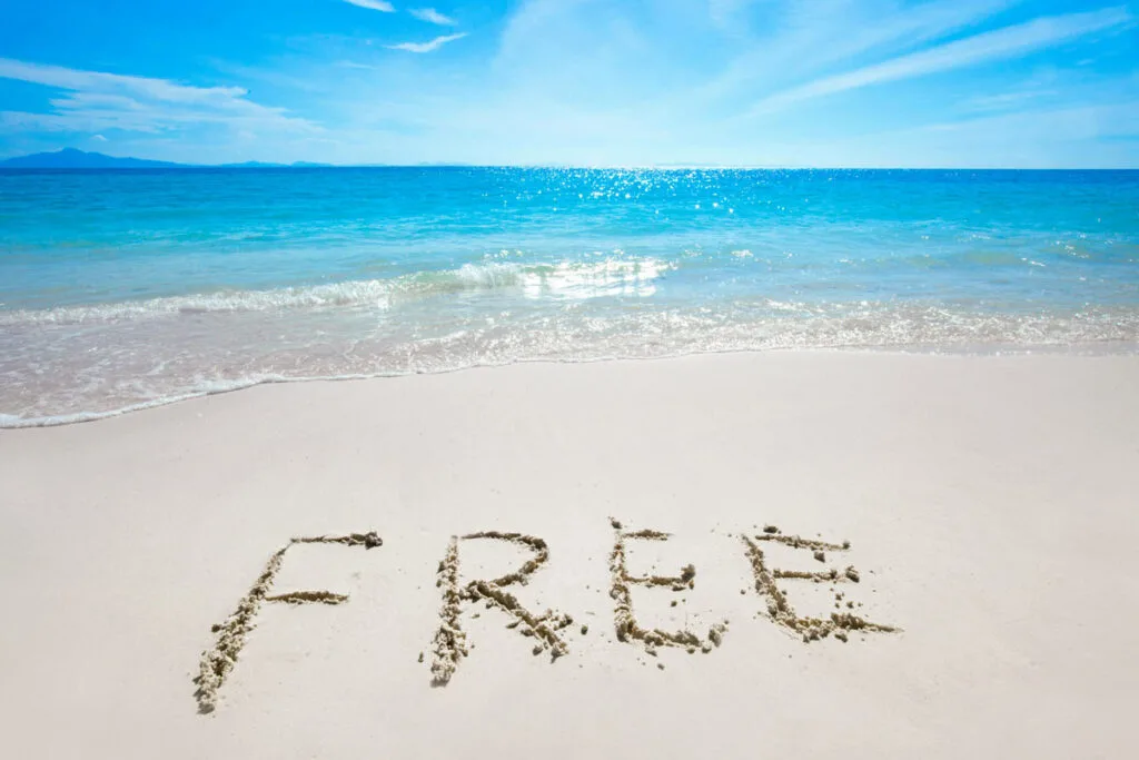 Sandy beach with blue skies and the word "FREE' etched into the sand