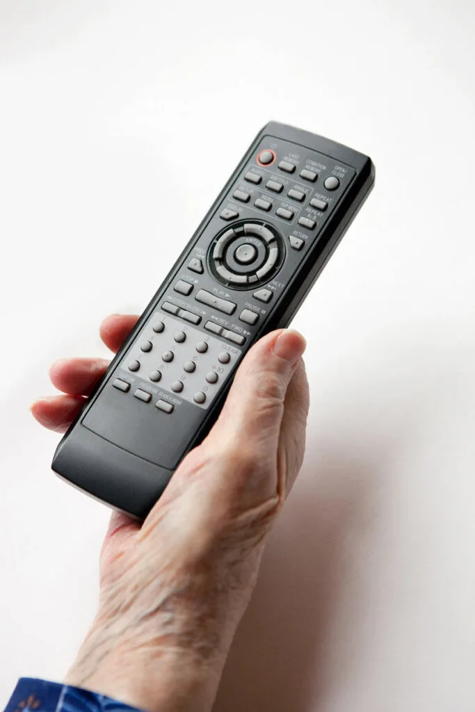 Hand holding on to a remote control.