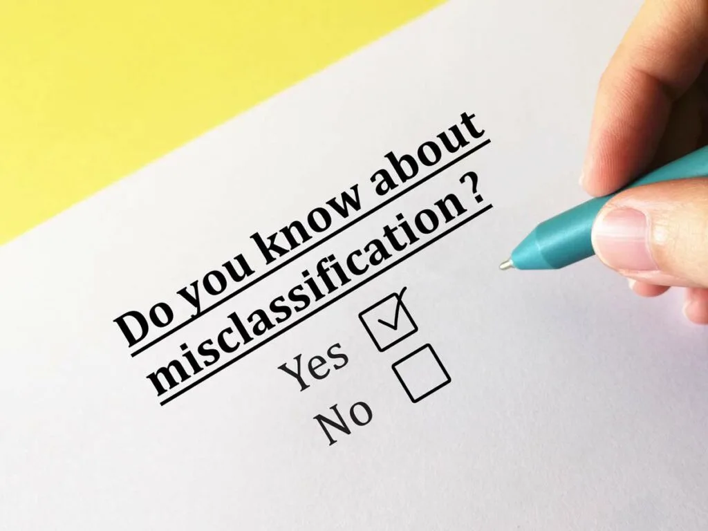 A printed survey question asking Do you know about misclassification? with a hand checking off the Yes box.